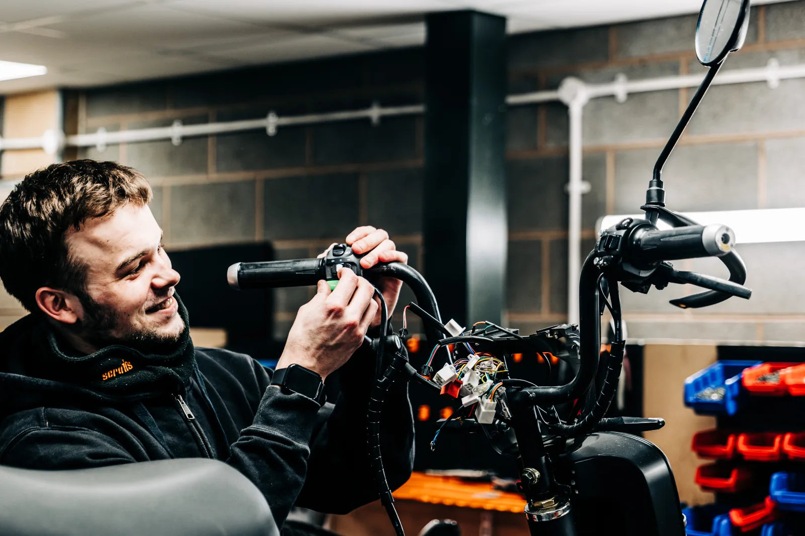 An Eskuta technician fitting handlebar controls and wiring to an SX-250 in the Nuneaton workshop