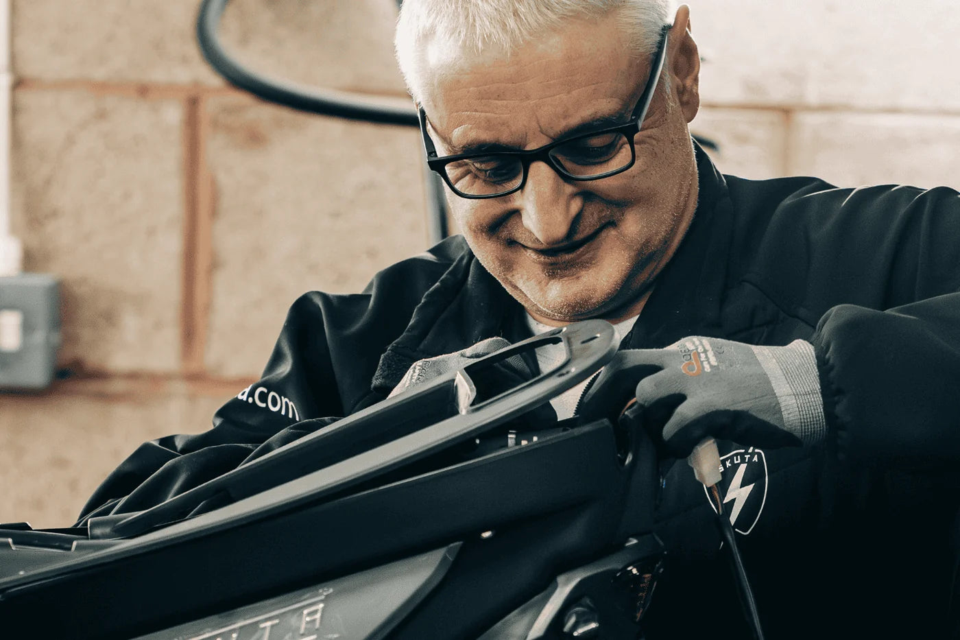 An Eskuta technician in a branded jacket hand-assembling an SX-250 in the Nuneaton workshop